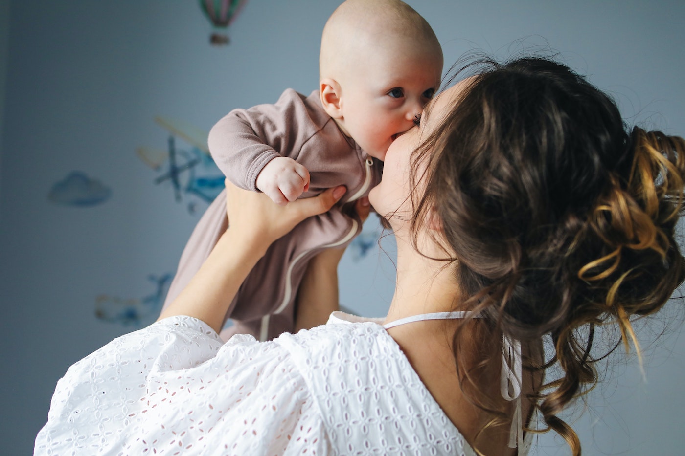 Woman lifting and kissing her baby