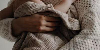 woman holding her baby in a blanket