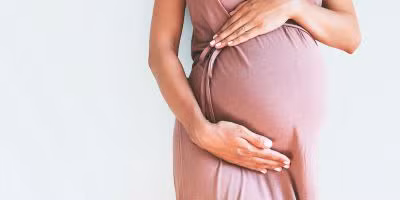 Pregnant woman holding her belly after successful IVF pregnancy