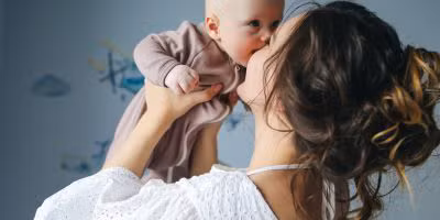 Woman lifting and kissing her baby