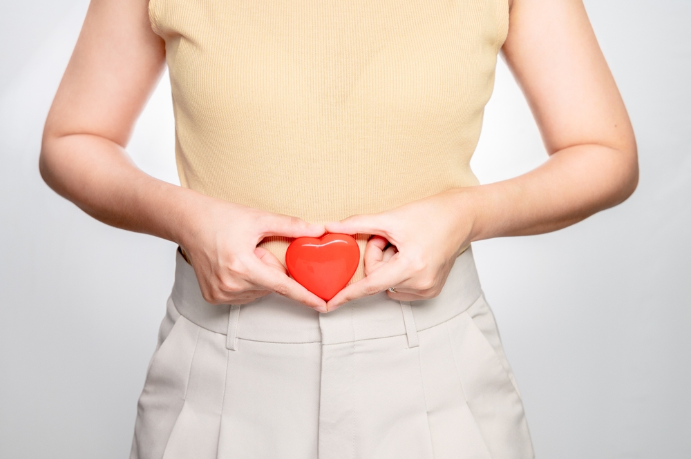 person holding a heart near her stomach indicating pregnancy