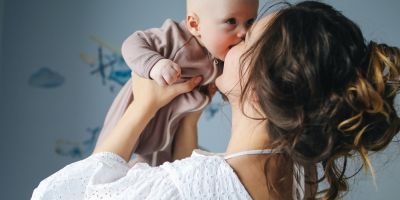 Woman lifting and kissing her baby