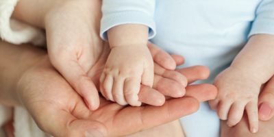 parents holding their baby's hand after fertility treatment