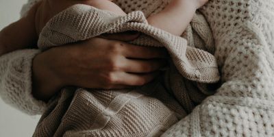 woman holding her baby in a blanket