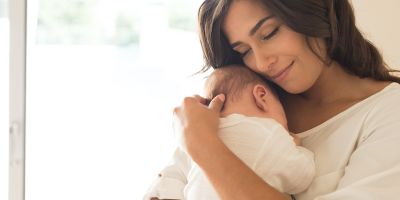 Mother holding baby after successful assisted hatching and north Houston IVF treatment
