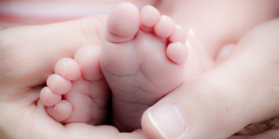 parents holding newborn baby's feet after healthy birth