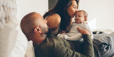 Multiracial couple playing with their IVF baby