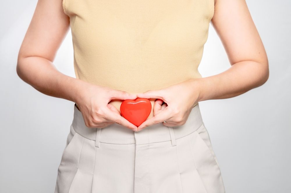 person holding a heart near her stomach indicating pregnancy